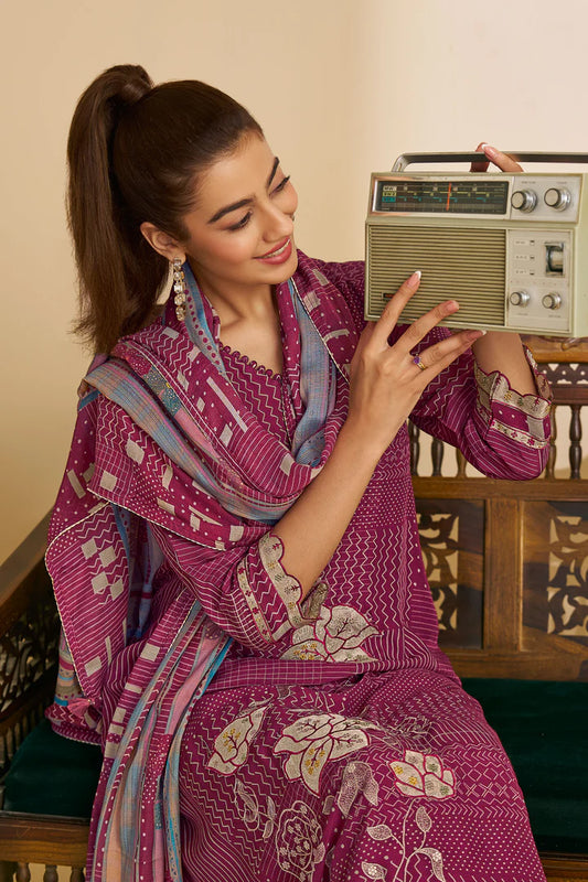 Woman in a traditional pink outfit sitting next to a vintage radio.